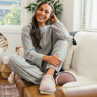 A model seated on a couch wearing the Cobian Carmel Moccasin Pink #color_pink