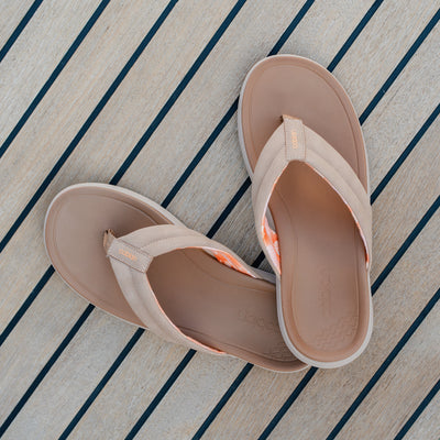 A close up of Cobian Darby Tan sandals on a boat deck #color_tan