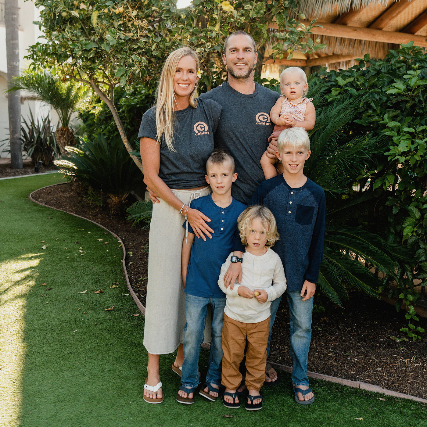 Bethany Hamilton and Adam Dirks wearing the Cobian Salt + Light Arc T-Shirt with their family #color_charcoal